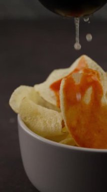 Dikey yemek videosu. Meyve sıkacağı ile limon sıkma. Patates cipsi yavaş çekim.