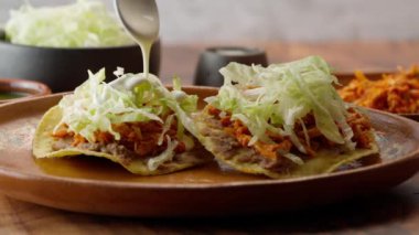 Meksika tostası, üzerine ekşi krema dökülen tavuk tinga ile birkaç tostada.