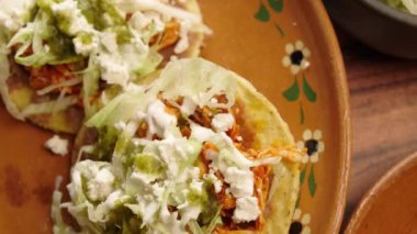 Mısır tostları, tavuk tinga, marul, ekşi krema, fasulye ve yeşil sos.