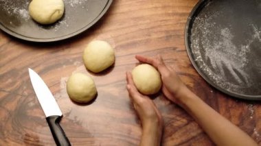 Geleneksel pan de Muerto yapmak için hamur yoğurdu yuvarlıyorum.