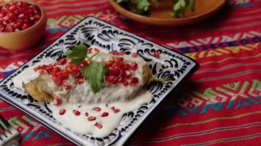 Meksika yemeği, kırmızı Meksika masa örtüsüyle nogada, sola dön.