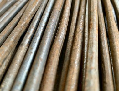 Close-up of stacked rusty steel rebar rods, rough texture and corrosion detail. Perfect for construction, engineering, building, and architecture themes.
