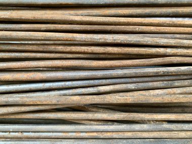 Close-up of stacked rusty steel rebar rods showing rough texture and detail. Industrial background perfect for construction, architecture, building, and engineering concepts.