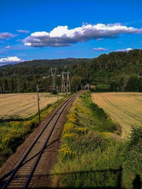 Huzurlu Tren, mavi gökyüzünü pofuduk beyaz bulutlarla kaplıyor..