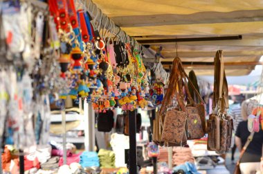 Sahil Pazarı 'ndaki renkli hediyelik eşya mağazası renkli anahtarlıklar, çantalar ve kıyı pazarındaki diğer hediyelik eşyalarla dolu bir market tezgahının canlı bir görüntüsü. Bu fotoğraf bir hareketliliğin özünü yakalar.