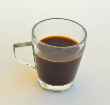 Pürüzsüz, şeffaf cam bardakta, koyu renk ve içeceğin pürüzsüz dokusunu vurgulayan koyu, sade bir kahve.. 