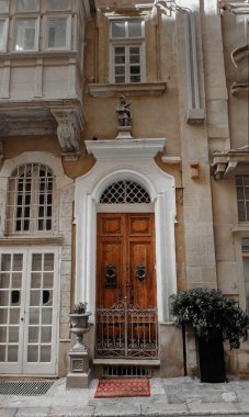 Heykeltraş edilmiş beyaz kemerli görkemli ahşap kapı süslü demir kapı ve klasik detaylar. Zengin dokular ve tarihi cazibe, onu kalıtım mimarisi için mükemmel bir özellik haline getiriyor. 
