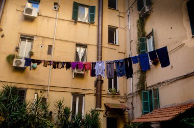 Bir Roma dairesinin cazibesini deneyin: temiz mavi gökyüzüne karşı çamaşır ipinde kuruyan yeni yıkanmış beyaz tişörtler