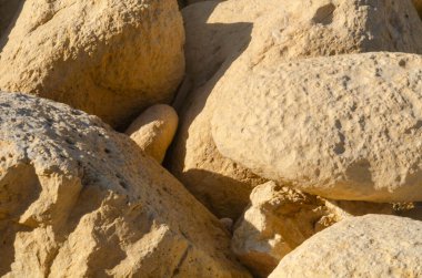 Sari kireçtaşı kayalarin detayli yakin planlari, engebeli dokular, jeoloji temaları ve dogal tasarim projeleri için ideal.