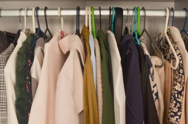 Paltoları, elbiseleri ve çeşitli şık parçaları olan güzel bir kadın gardırobu, dağınık ve ulaşılabilir moda koleksiyonu sağlıyor..