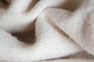 Yumuşak, kabarık beyaz yün kumaş ve detaylı doku. Kış modası, tekstil ve rahat arka planlar için ideal.