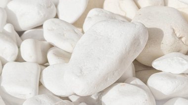 Pürüzsüz desenli parlak beyaz çakıl taşları tasarım, bahçe yolları ve doğal taş kavramları için ideal.