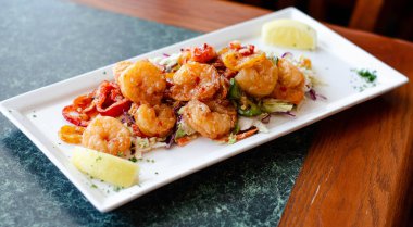 Dilimlenmiş jalapeno ve limon dilimleri ile süslenmiş taze lahana salatası yatağında servis edilen kızarmış karidesin iştahı açıldı. Deniz ürünleri çok güzel sunulmuş. 