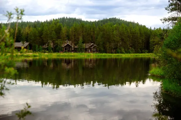  Sakin bir göl kenarındaki manzaralı ahşap ev sık yeşil ağaçlar ve doğal güzelliklerle çevrili..