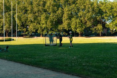 Baseball players are practicing their game in the park, honing their skills in an outdoor setting clipart