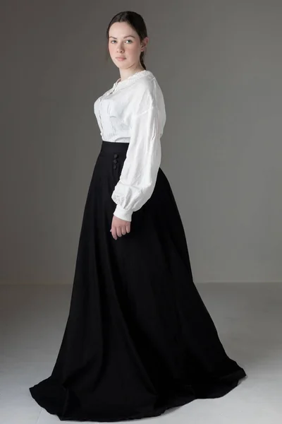白いリネンのガリバルディのブラウスと黒のスカートを着た若いビクトリア朝またはエドワード朝の女性 ロイヤリティフリーのストック画像