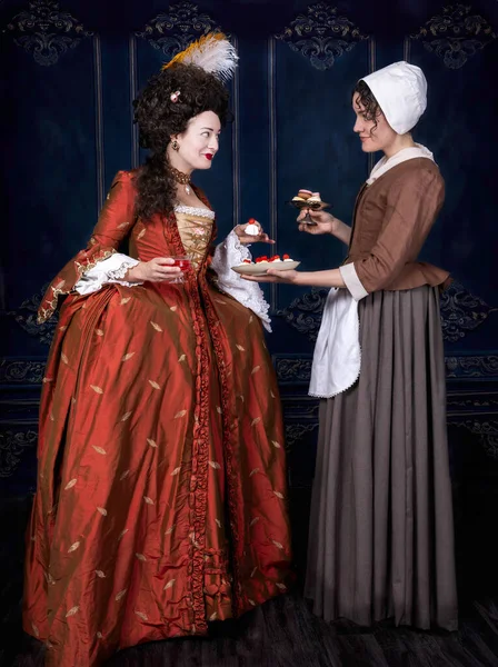 18世紀 メイドが保有するトレイからケーキを受け取る女性 ストック写真
