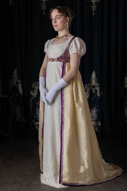 Gece kıyafeti giyen bir naip kadın, nakışlı bir elbise, uzun bir spencer ve eldiven.