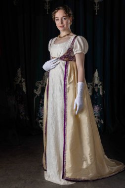 Gece kıyafeti giyen bir naip kadın, nakışlı bir elbise, uzun bir spencer ve eldiven.