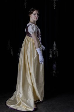 Gece kıyafeti giyen bir naip kadın, nakışlı bir elbise, uzun bir spencer ve eldiven.