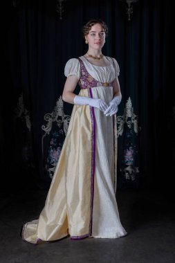 Gece kıyafeti giyen bir naip kadın, nakışlı bir elbise, uzun bir spencer ve eldiven.