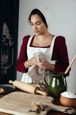 Regency işçi sınıfı bir kadın ya da hizmetçi önlük giyip yemek pişiriyor. 