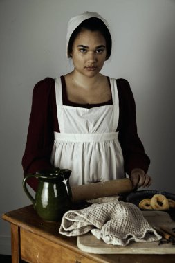 Regency işçi sınıfı bir kadın ya da hizmetçi önlük giyip yemek pişiriyor. 