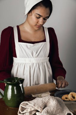 Regency işçi sınıfı bir kadın ya da hizmetçi önlük giyip yemek pişiriyor. 