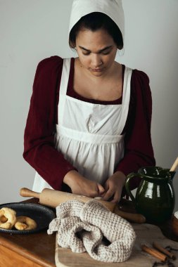 Regency işçi sınıfı bir kadın ya da hizmetçi önlük giyip yemek pişiriyor. 