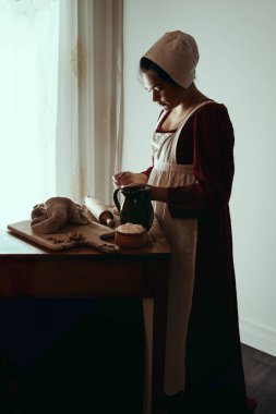 Regency işçi sınıfı bir kadın ya da hizmetçi önlük giyip yemek pişiriyor. 