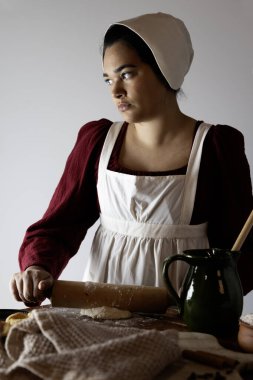 Regency işçi sınıfı bir kadın ya da hizmetçi önlük giyip yemek pişiriyor. 