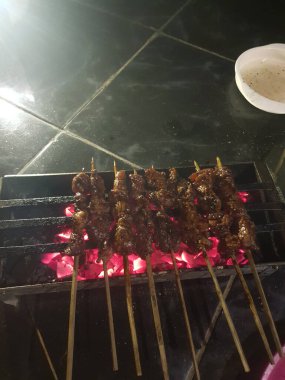 Yanan kömürün üzerinde şiş et ızgarası, yanında sos sosu..