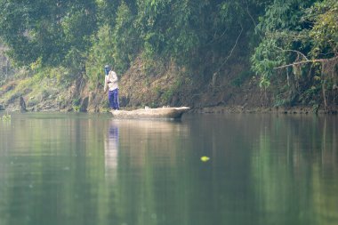 Nepal 'de bir nehrin kıyısındaki kanoda kalan bir adam..