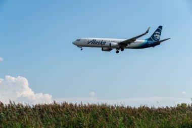 Bir Alaska Havayolları uçağı gökyüzündeki bulutlara karşı inişe geçiyor: Philadelphia - Pennsylvania, 27 Ağustos 2022.