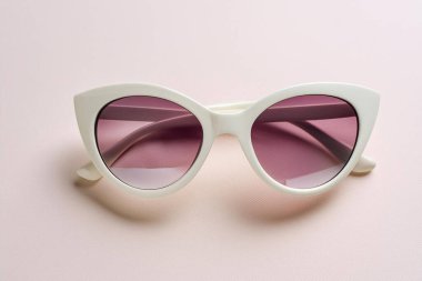 Pembe arka planda moda güneş gözlükleri, üst manzara