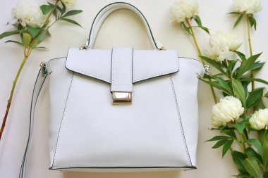 Beyaz deri ve çiçekli beyaz bir çanta. moda aksesuarlar.