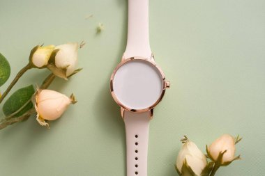 Pembe arka planda güller olan şık bir saat.