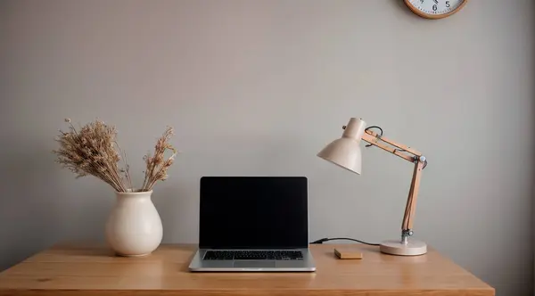 Gri duvarın yanındaki beyaz masada dizüstü bilgisayarı, lambası, fincanı ve dekoru olan şık bir iş yeri. Yüksek kalite fotoğraf