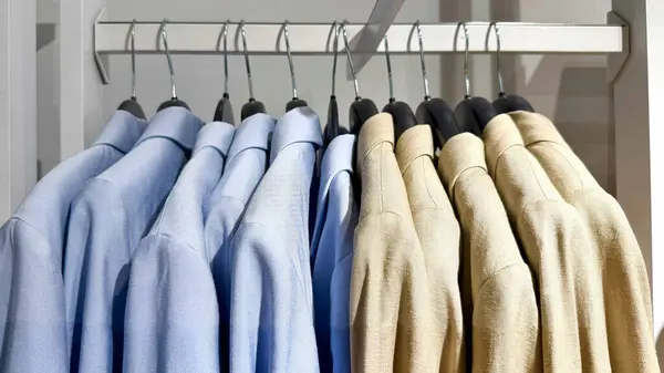 Tarafsız bir arkaplanda mağazadaki askılarda asılı ceketler. Yüksek kalite fotoğraf