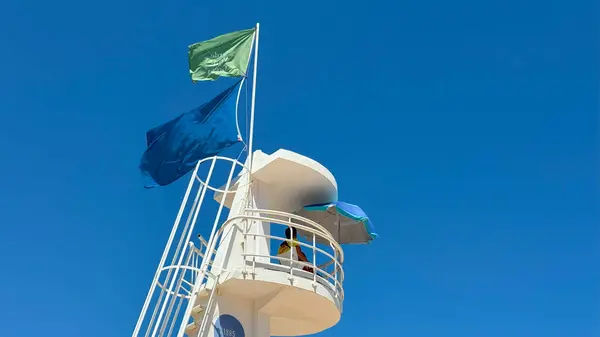 Mavi gökyüzünde arka plan olarak beyaz cankurtaran kulesi. Plaj güvenliği, turizm veya kıyı mimarisi için uygun bir görüntü. Uzayı metin için kopyala. Yüksek kalite fotoğraf