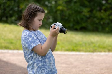 Küçük bir kız kamerayla doğanın fotoğraflarını çekiyor. Yüksek kalite fotoğraf