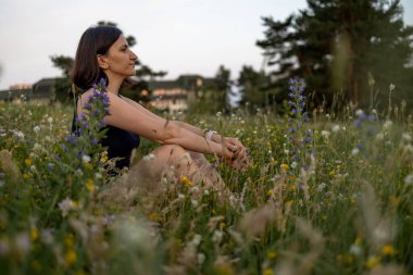 Hayalperest genç bir kız doğada oturuyor. Yüksek kalite fotoğraf