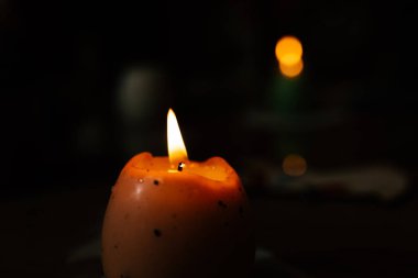 Küçük, turuncu bir mum yumuşak bir şekilde yanar, sıcacık, loş bir çevrede sıcak bir parıltı bırakır. Davetkar ortam arkadaşlarla rahat bir akşam geçirmek için ortam hazırlıyor..