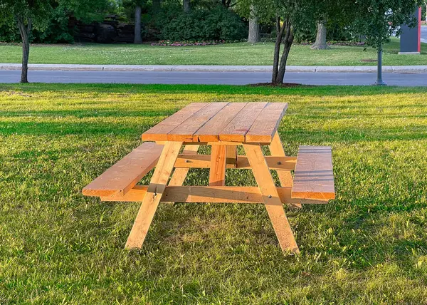 stock image Light-Brown Wooden Picnic Table on Green Grass in a Park