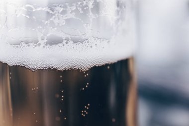 Bira bardağındaki köpüklerin yakın çekimi.