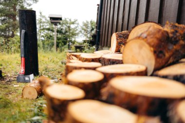 Ön planda bir odun yığını, arka planda da bir balta. Norveç dağ kulübesi.