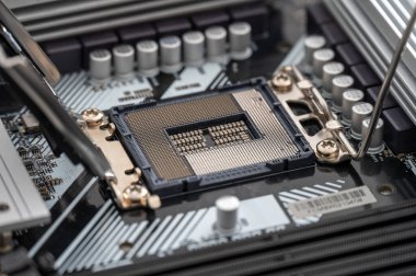 Modern bir anakart üzerinde açık bir işlemci soketinin yüksek çözünürlüklü görüntüsü, karmaşık pin düzenini ve yakınlardaki bileşenleri detaylandırır.