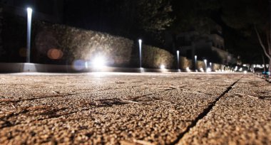 LED ışıklarının yol açtığı büyüleyici şehir manzarası. Görüntü, manzaralı çitlerin kenarındaki bir şehir geçidini vurgulayan gösterişli, modern sokak aydınlatmasını ön plana çıkarıyor. Kentsel tasarım ve aydınlatma estetiği için ideal.