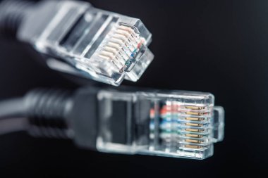 Karmaşık pin yapılandırmalarını gösteren iki ethernet konnektörü belirgin bir şekilde görüntülenir. Şeffaf tasarım, modern dijital iletişim sistemlerinde ve ağ altyapısında bağlanabilirliğin önemini vurgulayarak, kablo renklerini ortaya çıkarır.