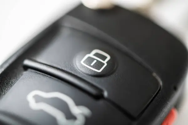 stock image A detailed view of a car key remote featuring lock and unlock buttons. Ideal for automotive technology themes. Perfect for showcasing modern vehicle security and convenience in everyday life.